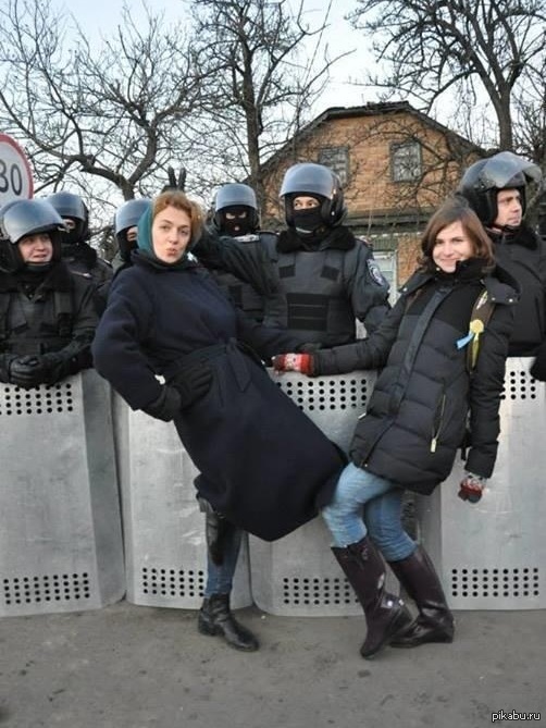 Активисты Евромайдана позируют на фоне бойцов внутренних войск у резиденции президента